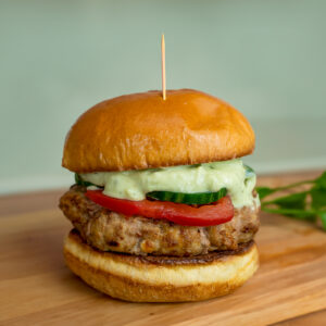 Greek turkey burger on cutting board