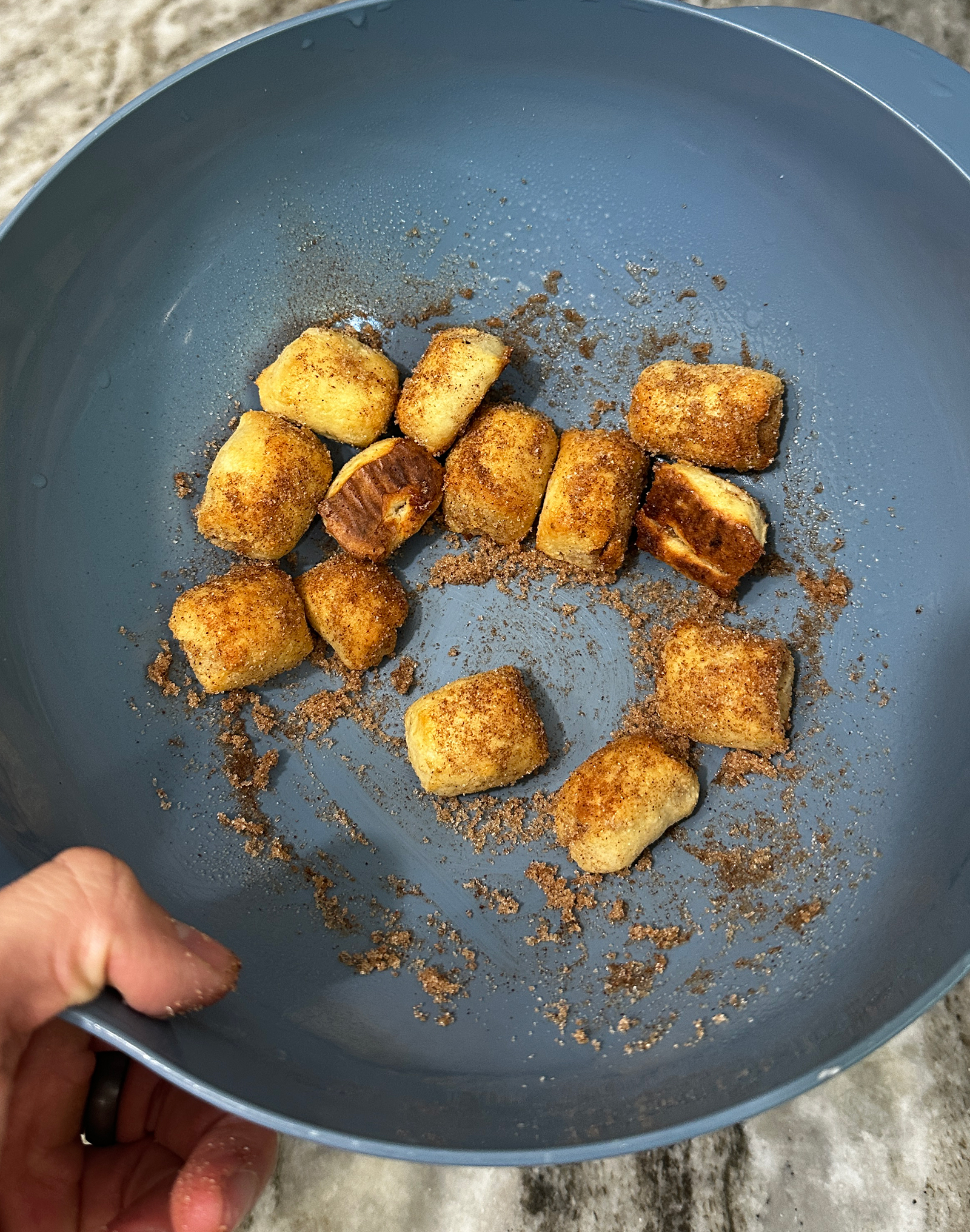 Tossing bagel bites in cinnamon sugar